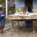 Una mujer sostiene un teléfono en el exterior de una vivienda en la región de San Antonio del Sur una semana después del paso de la tormenta tropical Oscar. Foto: Ernesto Mastrascusa / POOL / EFE.