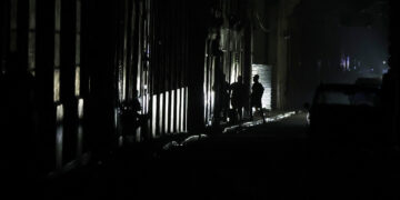 Personas caminan de noche en una calle de La Habana durante durante el apagón por la desconexión total del sistema eléctrico de Cuba. Foto: Ernesto Mastrascusa / EFE.