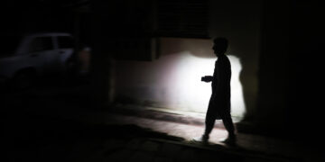 Un hombre camina de noche en una calle de La Habana durante el apagón por la desconexión total del sistema eléctrico de Cuba. Foto: Ernesto Mastrascusa / EFE.