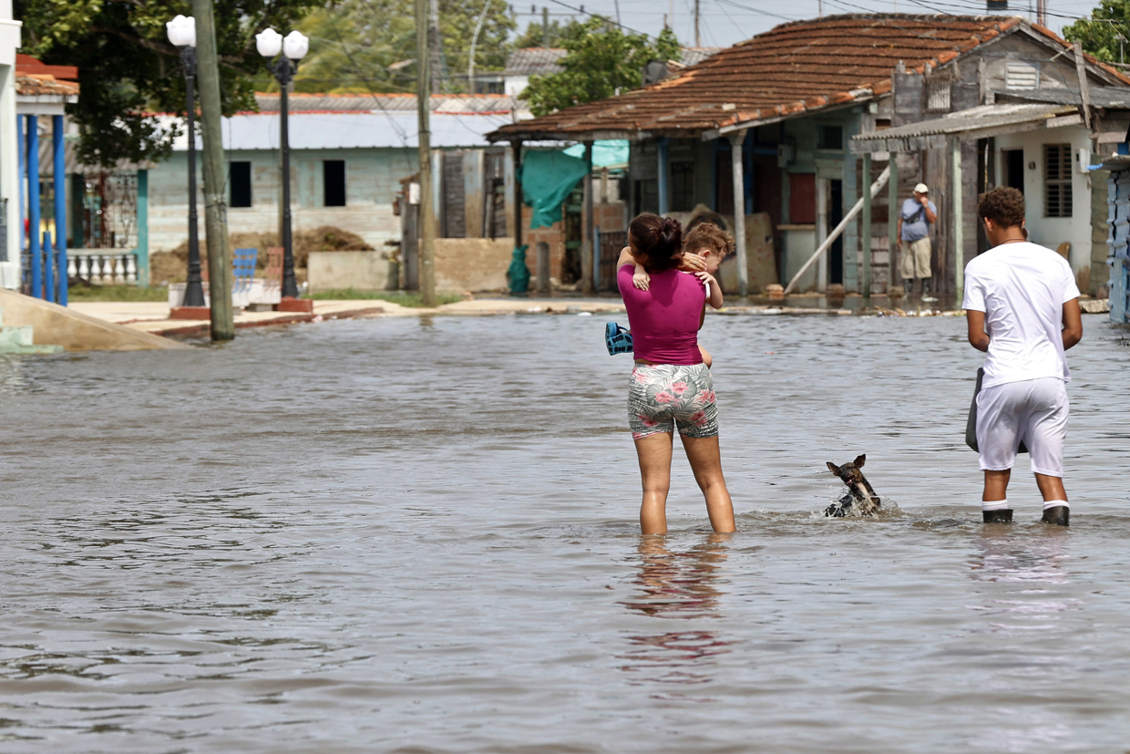 Personas caminan por una calle afectada por las inundaciones provocadas por el huracán Milton en Batabanó, en la costa sur del occidente de Cuba. Foto: Ernesto Mastrascusa / EFE.