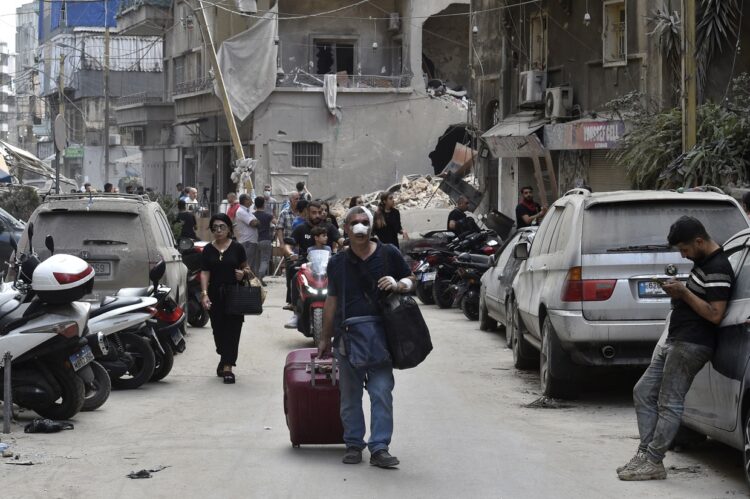 Personas cargan con sus pertenencias después de un ataque de Israel a un barrio de Beirut. Foto: WAEL HAMZEH/EFE/EPA.