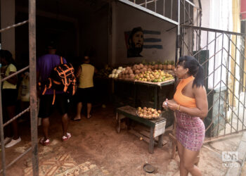 Una mujer pasa frente a un mercado agropecuario en La Habana, durante el apagón general provocado por una desconexión total del Sistema Electroenergético de Cuba. Foto: Otmaro Rodríguez.