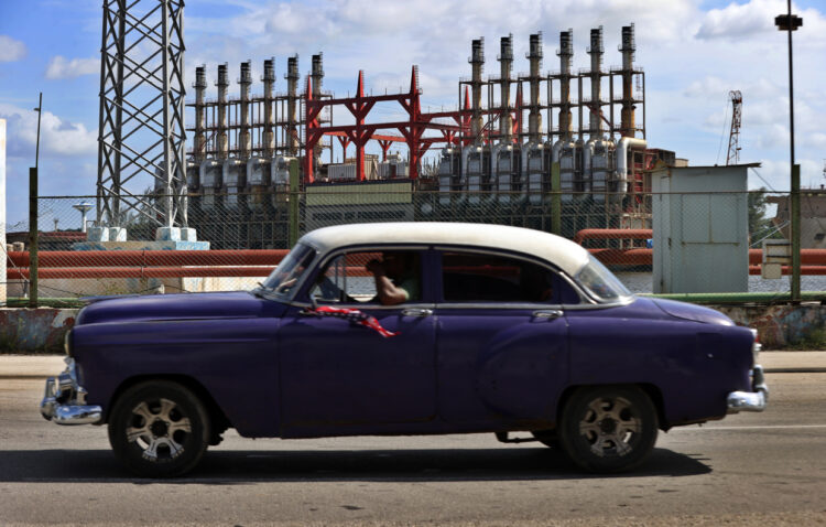 Un auto clásico pasa frente a una de las plantas turcas de generación eléctrica en el puerto de La Habana, durante los días del colapso del Sistema Electroenergético de Cuba. Foto: Ernesto Mastrascusa / EFE.