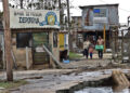 Una familia camina con sus pertenencias por una calle afectada tras el paso del huracán Rafael, en Playa Majana, en la provincia de Artemisa. Foto: Ernesto Mastrascusa / EFE.