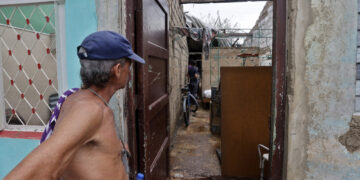 Un hombre observa los daños causados en su vivienda por el huracán Rafael, en Artemisa. Foto: Ernesto Mastrascusa / EFE.