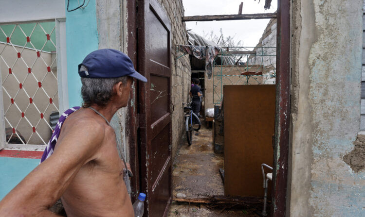 Un hombre observa los daños causados en su vivienda por el huracán Rafael, en Artemisa. Foto: Ernesto Mastrascusa / EFE.