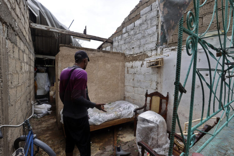 Un hombre observa los daños causados en su vivienda por el huracán Rafael, en Artemisa. Foto: Ernesto Mastrascusa / EFE.