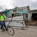 Un hombre transita en bicicleta frente a una vivienda con el techo caído tras el paso del huracán Rafael, en la provincia de Artemisa. Foto: Ernesto Mastrascusa / EFE.