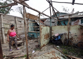 Una mujer observa su vivienda destrozada por el huracán Rafael, en Artemisa. Foto: Ernesto Mastrascusa / EFE.