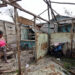 Una mujer observa su vivienda destrozada por el huracán Rafael, en Artemisa. Foto: Ernesto Mastrascusa / EFE.