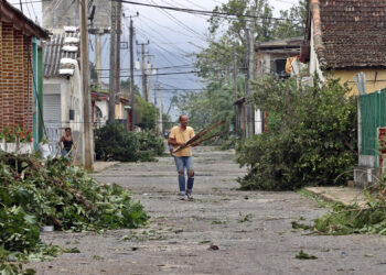 Un hombre recoge escombros en una calle, el 7 de noviembre de 2024, tras el paso del huracán Rafael, este jueves la provincia de Artemisa (Cuba). Foto: Ernesto Mastrascusa/EFE.