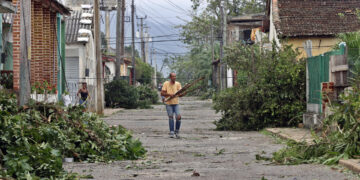 Un hombre recoge escombros en una calle, el 7 de noviembre de 2024, tras el paso del huracán Rafael, este jueves la provincia de Artemisa (Cuba). Foto: Ernesto Mastrascusa/EFE.