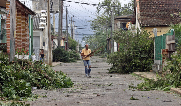 Un hombre recoge escombros en una calle, el 7 de noviembre de 2024, tras el paso del huracán Rafael, este jueves la provincia de Artemisa (Cuba). Foto: Ernesto Mastrascusa/EFE.