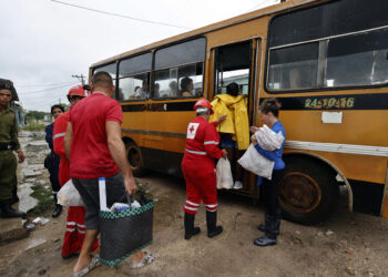 Integrantes de la Cruz Roja cubana ayudan a unas personas a subir a un autobús durante una evacuación en el Surgidero de Batabanó antes de la llegada del huracán Rafael a Cuba, en noviembre de 2024. Foto: Ernesto Mastrascusa / EFE / Archivo.