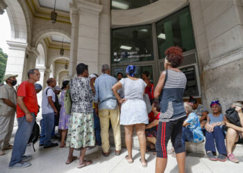 Personas hacen fila para entrar a una entidad bancaria tras un apagón. Foto: Yander Zamora/EFE.