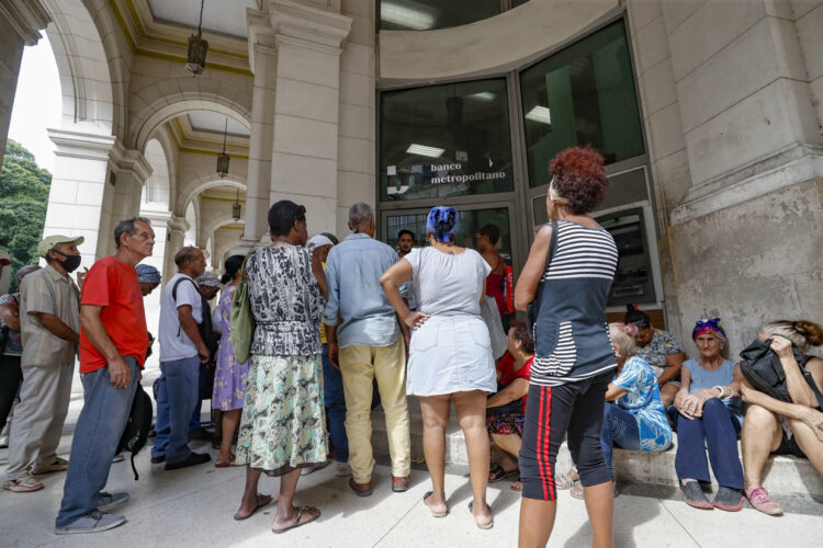 Personas hacen fila para entrar a una entidad bancaria tras un apagón. Foto: Yander Zamora/EFE.