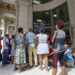 Personas hacen fila para entrar a una entidad bancaria tras un apagón. Foto: Yander Zamora/EFE.