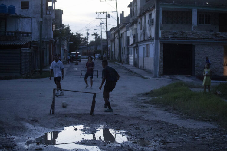 Jóvenes juegan fútbol durante un apagón, en el Cerro, La Habana. Foto:  Yander Zamora/EFE.