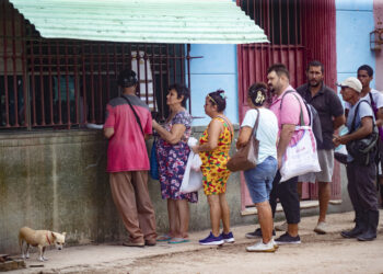 Varias personas hacen fila para comprar alimentos en un negocio en el pueblo de Bejucal. Foto: EFE/ Yander Zamora.