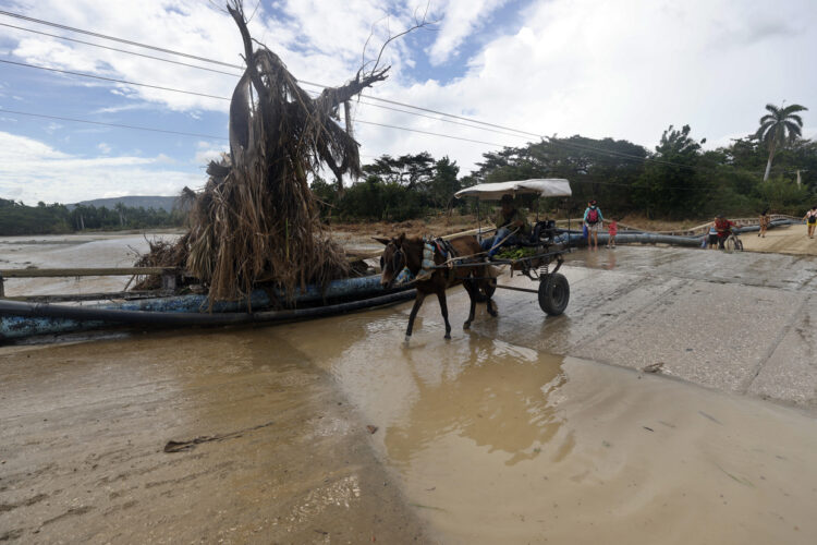 Un hombre transita por una calle inundada en la región de San Antonio del Sur tras el paso de la tormenta tropical Óscar, en Guantánamo. Foto: Ernesto Mastrascusa/ POOL/EFE.