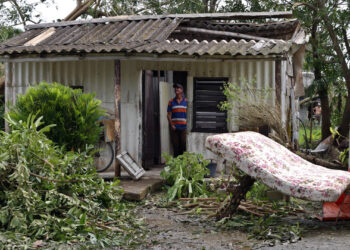 Imagen ilustrativa. Un hombre observa el techo de su vivienda destrozado tras el paso del huracán Rafael (nov. 2024) en la provincia de Artemisa. EFE/ Ernesto Mastrascusa