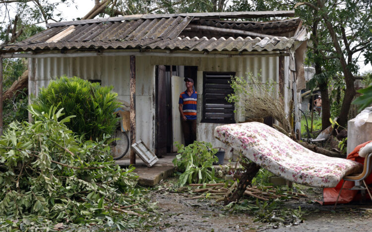 Imagen ilustrativa. Un hombre observa el techo de su vivienda destrozado tras el paso del huracán Rafael (nov. 2024) en la provincia de Artemisa. EFE/ Ernesto Mastrascusa