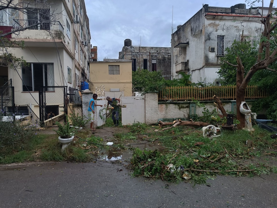 Vecinos sacan escombros a la calle en el Vedado, La Habana, un día después del azote del huracán Rafael. Foto: Milena Recio.