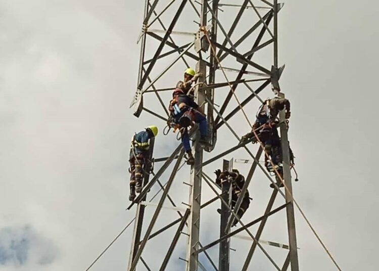 Técnicos de la Unión Eléctrica (UNE) trabajan en una de las torres de alta tensión levantadas en Artemisa, luego de ser derrumbadas por el huracán Rafael. Foto: UNE / Facebook.