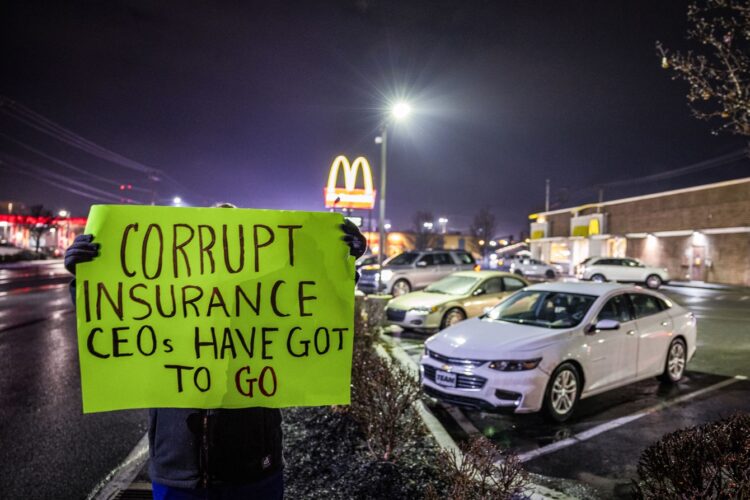 Una mujer que no quiso ser identificada y que trabaja en la industria de la salud, sostiene un cartel de protesta en las afueras del McDonald's donde el Departamento de Policía arrestó a Luigi Mangione, acusado de asesinar a un alto ejecutivo de las aseguradoras en la ciudad de Nueva York. Foto: EFE/EPA/CAMERON CROSTON.