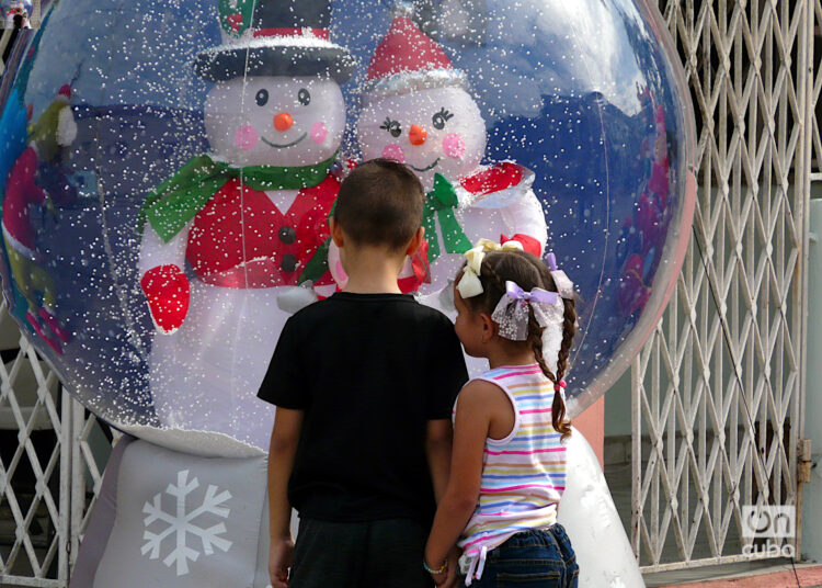 Niños contemplan unos adornos navideños en La Habana. Foto: A.M.D.