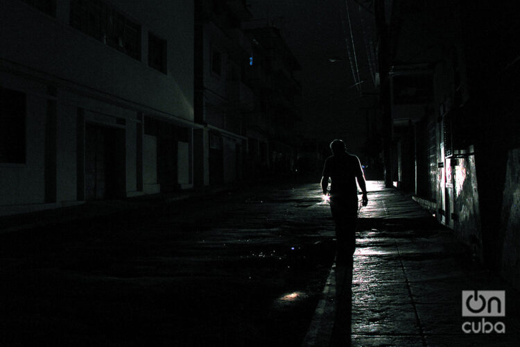 Una persona camina por una calle durante un apagón nocturno en La Habana. Foto: Alejandro Ernesto / Archivo.