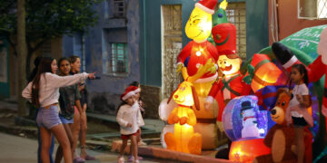 Personas observan decoración navideña, en La Habana. Foto: Ernesto Mastrascusa/ EFE.