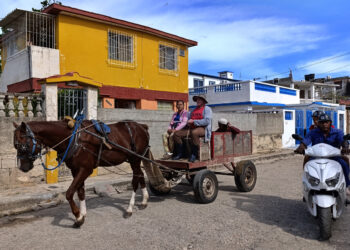 Personas se transportan en un carretón en La Habana. Foto: Ernesto Mastrascusa /EFE.