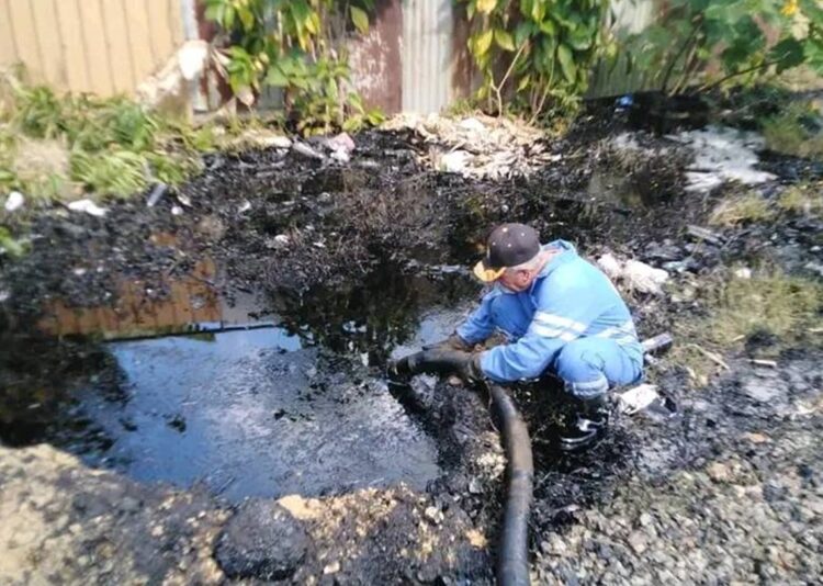 Un trabajador de la Refinería Sergio Soto, de Cabaiguán, trabaja en la recuperación del crudo derramado por un choque de trenes en Sancti Spíritus. Foto: CUPET / Facebook.