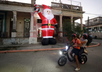 Personas observan decoración navideña, en La Habana (Cuba). Foto: Ernesto Mastrascusa/EFE.