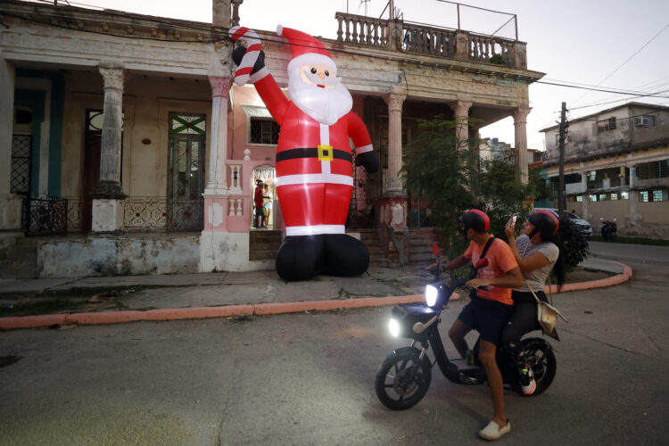 Personas observan decoración navideña, en La Habana (Cuba). Foto: Ernesto Mastrascusa/EFE.