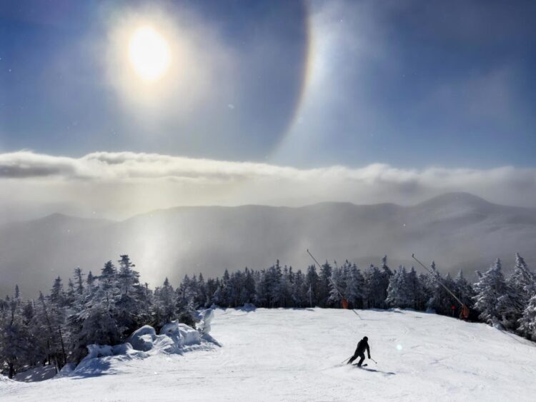 Los cristales de hielo en el aire forman un halo solar sobre el monte Mansfield mientras un esquiador desciende por la ladera en Stowe, Vermont, EE. UU., el 22 de diciembre de 2024. Foto: JIM LO SCALZO /EFE/EPA.