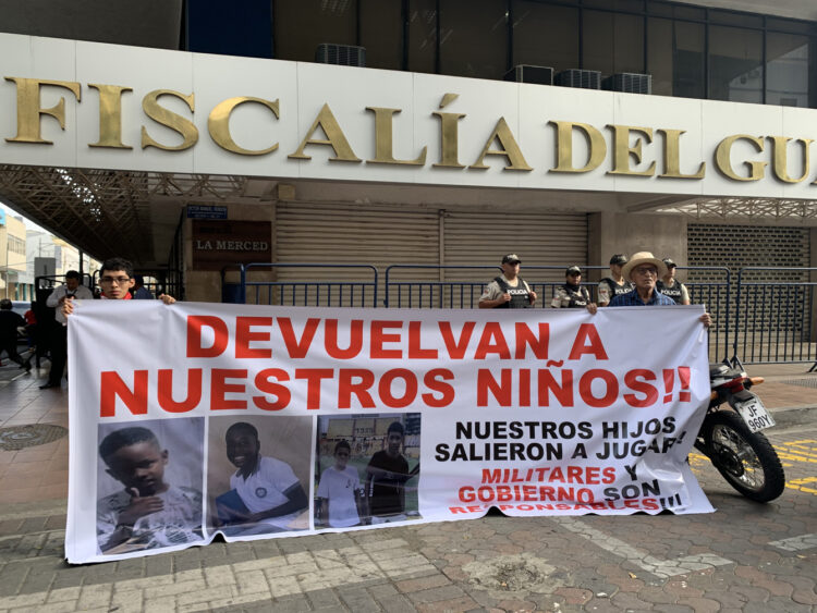 Dos personas sostienen un cartel en los exteriores de la Fiscalía Provincial del Guayas con el mensaje "devuelvan a nuestros niños", en alusión a los cuatro menores desaparecidos el 8 de diciembre en Guayaquil, Ecuador. Foto: Cristina Bazán / EFE.