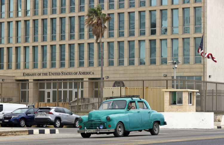 Un auto clásico de fabricación norteamericana, pasa frente a la embajada de Estados Unidos en La Habana. Foto: Ernesto Mastrascusa / EFE.