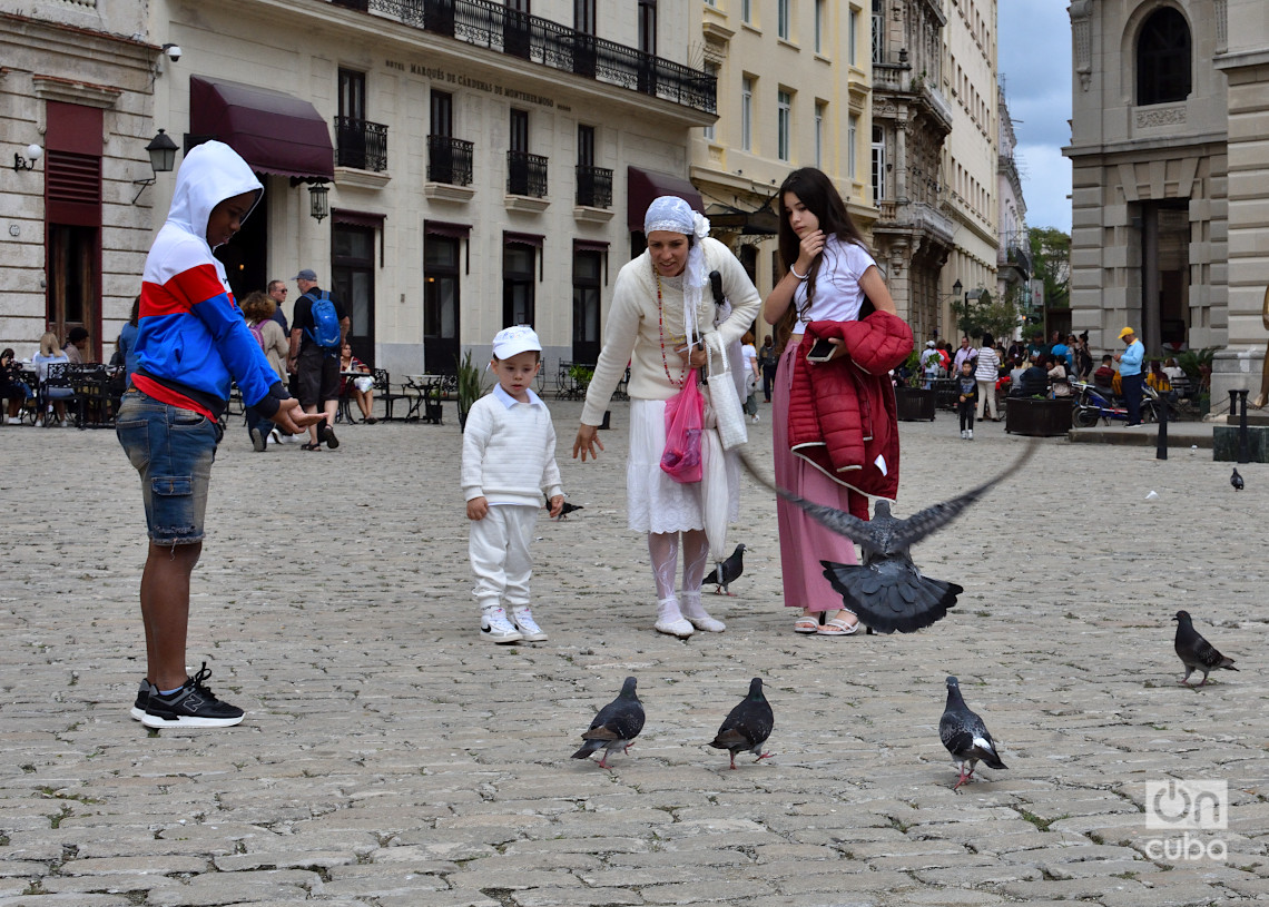 Una familia en la plaza de San Francisco de Asís, en La Habana, durante un frente frío. Foto: Otmaro Rodríguez.