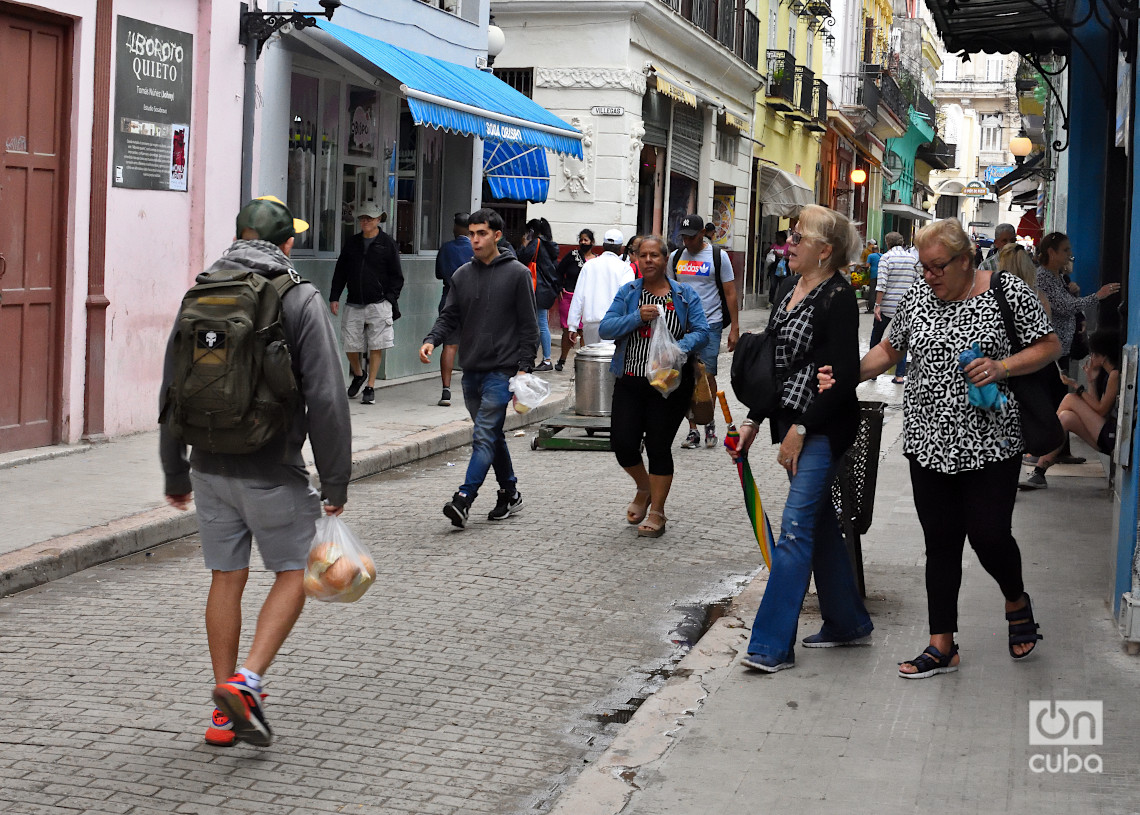 Personas en una calle de La Habana durante un frente frío. Foto: Otmaro Rodríguez.