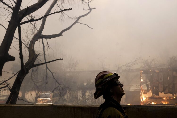 Un bombero del condado de Los Ángeles observa un incendio forestal en Altadena, California, donde se han ordenado decenas de miles de evacuaciones. Foto: Caroline Brahmán/EFE