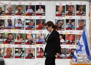 Una mujer pasa junto a una exposición imágenes de los rehenes israelíes secuestrados durante los ataques de Hamás a Israel del 7 de octubre de 2023, frente al cuartel general militar de Kirya en Tel Aviv, Israel, el 17 de enero de 2025. Foto: Abir Sultan / EFE.