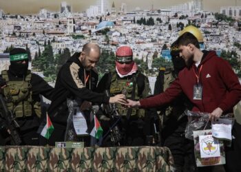 Militantes de Hamás y la Yihad Islámica se encuentran junto al rehén ruso-israelí Sasha (Alexander) Troufanov (d) y al rehén argentino-israelí Yair Horn (2i) antes de entregarlos al equipo de la Cruz Roja, en Khan Yunis. Foto: EFE/HAITHAM IMAD