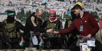 Militantes de Hamás y la Yihad Islámica se encuentran junto al rehén ruso-israelí Sasha (Alexander) Troufanov (d) y al rehén argentino-israelí Yair Horn (2i) antes de entregarlos al equipo de la Cruz Roja, en Khan Yunis. Foto: EFE/HAITHAM IMAD