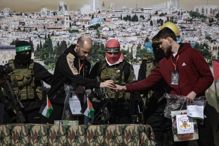 Militantes de Hamás y la Yihad Islámica se encuentran junto al rehén ruso-israelí Sasha (Alexander) Troufanov (d) y al rehén argentino-israelí Yair Horn (2i) antes de entregarlos al equipo de la Cruz Roja, en Khan Yunis. Foto: EFE/HAITHAM IMAD