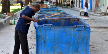 Un hombre busca algo que pueda aprovechar en unos contenedores de basura sorprendentemente vacíos en La Habana. Foto: Otmaro Rodríguez.