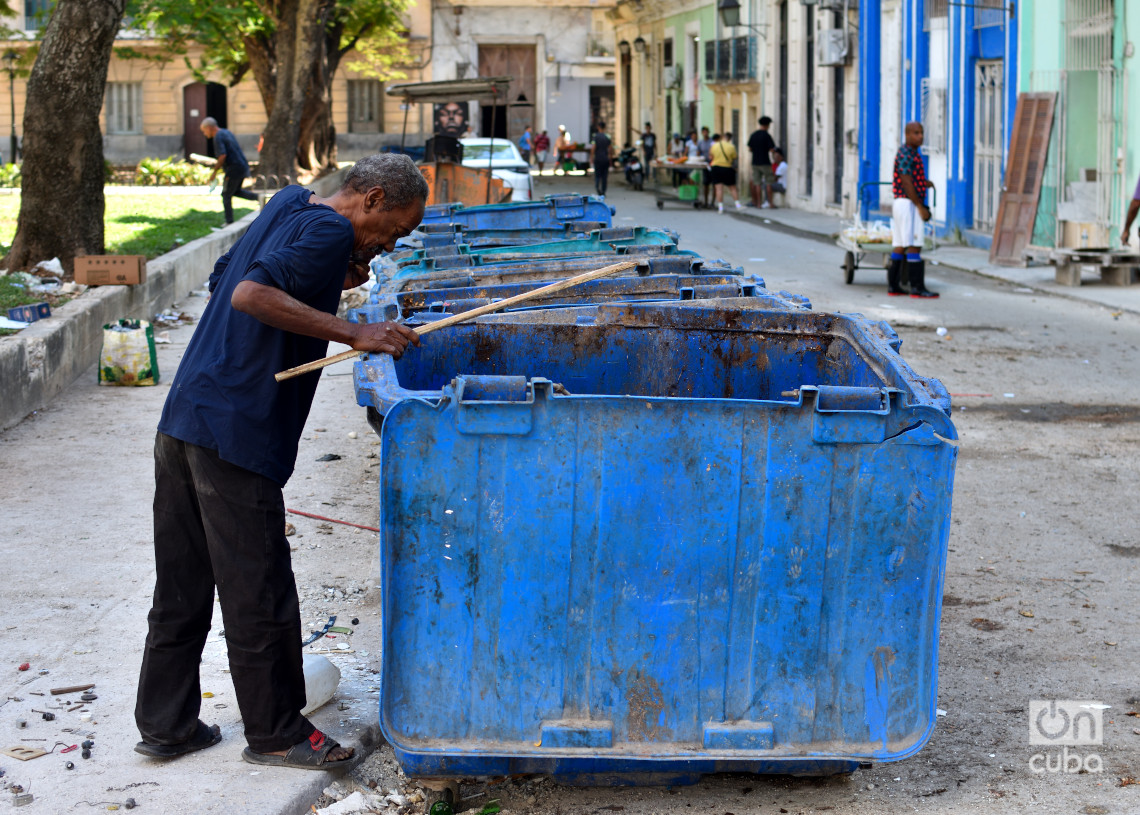 Un hombre busca algo que pueda aprovechar en unos contenedores de basura sorprendentemente vacíos en La Habana. Foto: Otmaro Rodríguez.