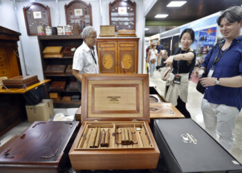 Personas asisten a la feria comercial del XXV Festival del Habano, este lunes en el Palacio de Convenciones. Foto: Ernesto Mastrascusa/EFE.