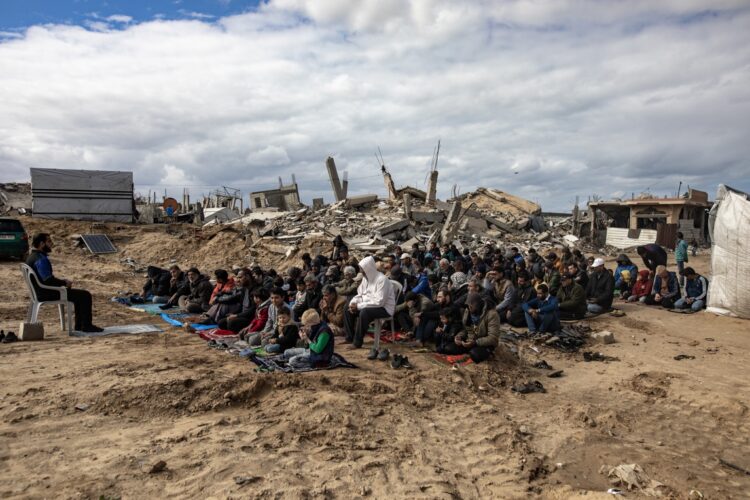 Palestinos rezan frente a sus hogares destruidos por los ataques israelíes, en Khan Yunis, sur de Gaza, 7 de febrero de 2025. Foto: EFE/EPA/HAITHAM IMAD.